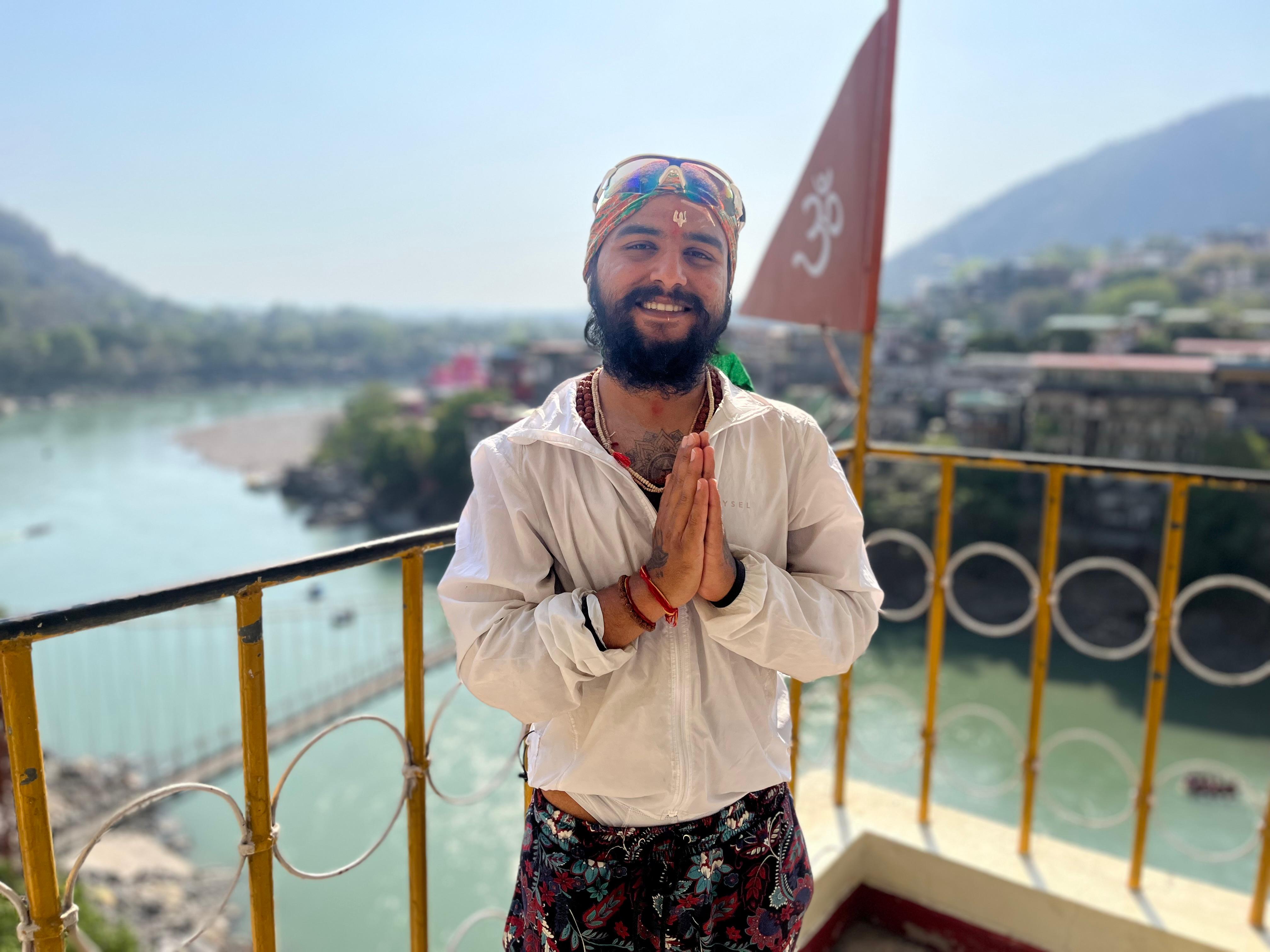 Divyesh in namaste with Om flag